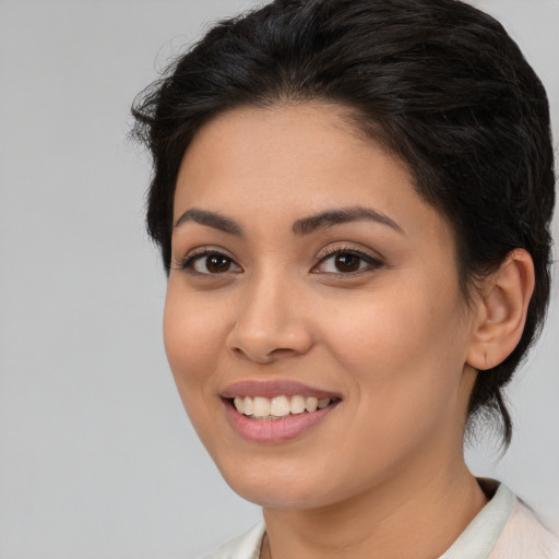 Joyful latino young-adult female with medium  brown hair and brown eyes