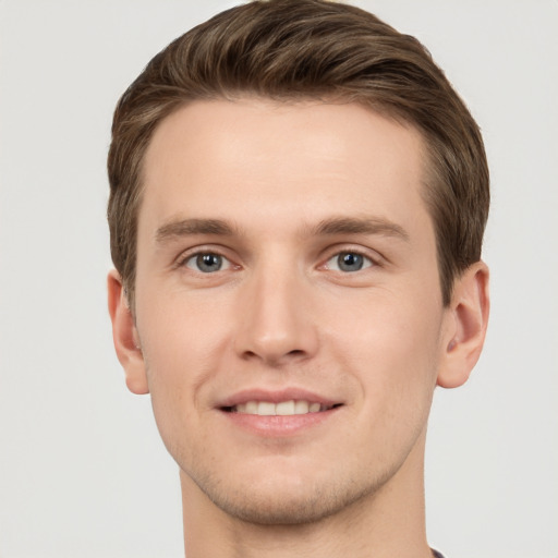 Joyful white young-adult male with short  brown hair and grey eyes