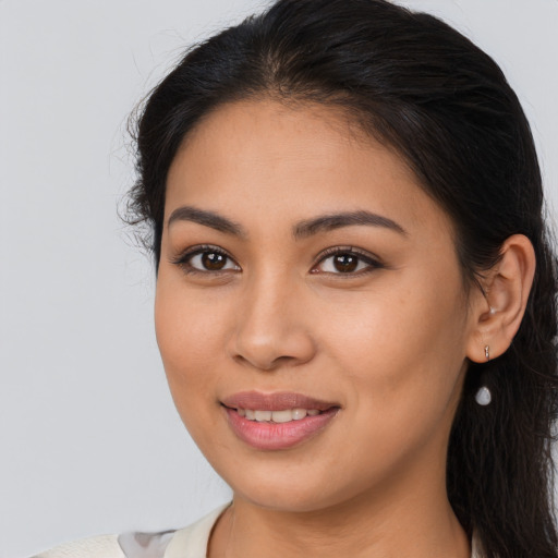 Joyful latino young-adult female with long  brown hair and brown eyes