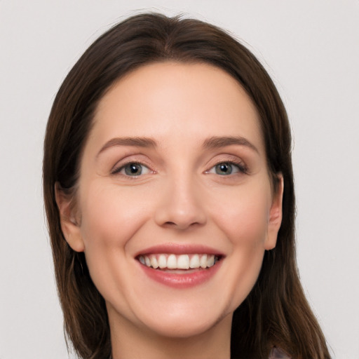 Joyful white young-adult female with long  brown hair and grey eyes