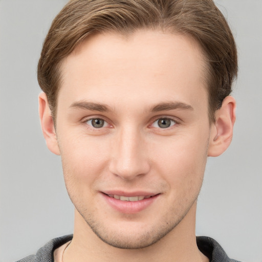 Joyful white young-adult male with short  brown hair and grey eyes