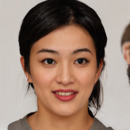 Joyful asian young-adult female with medium  brown hair and brown eyes