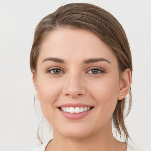 Joyful white young-adult female with medium  brown hair and grey eyes