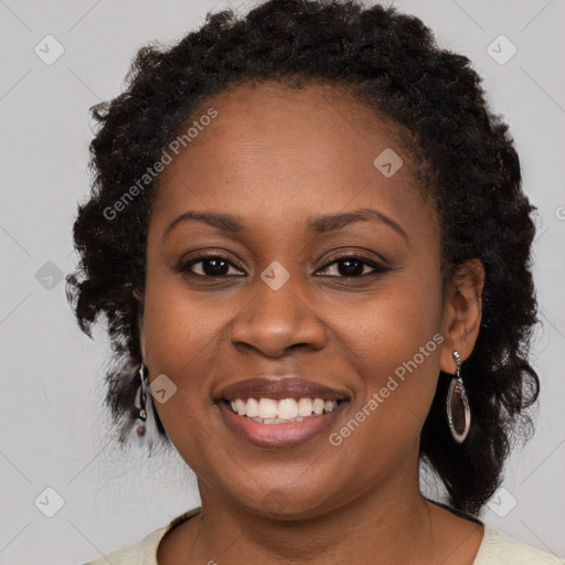 Joyful black young-adult female with long  brown hair and brown eyes