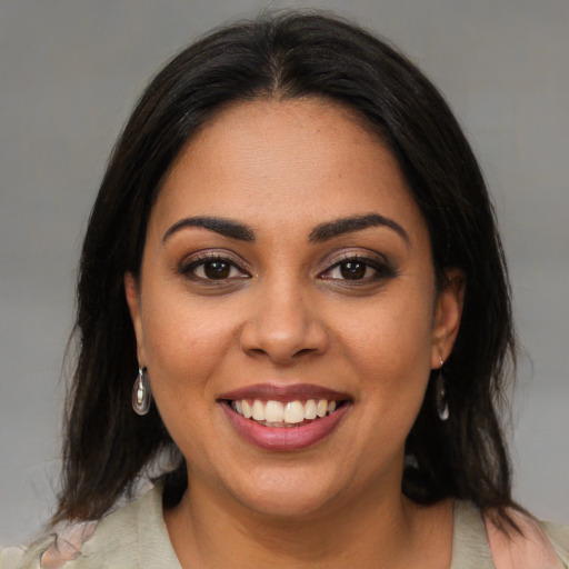 Joyful latino young-adult female with medium  brown hair and brown eyes