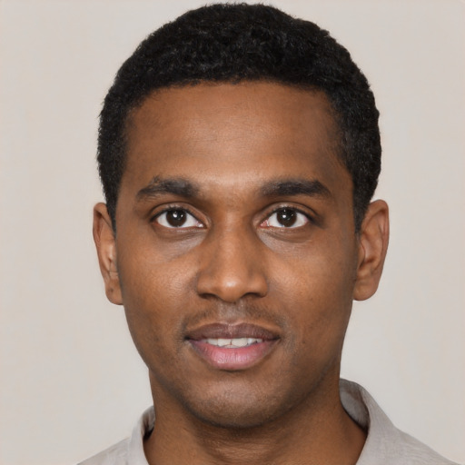 Joyful black young-adult male with short  black hair and brown eyes