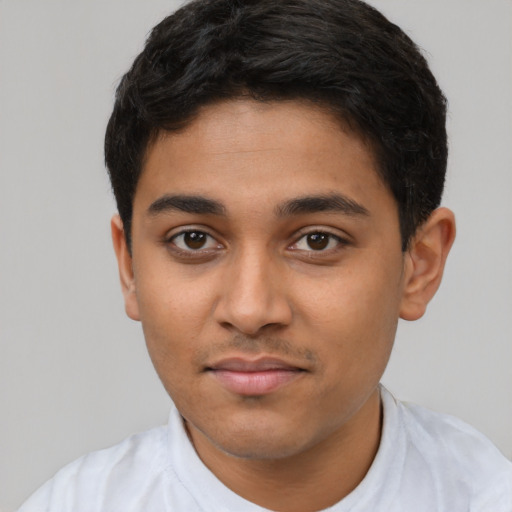 Joyful latino young-adult male with short  black hair and brown eyes