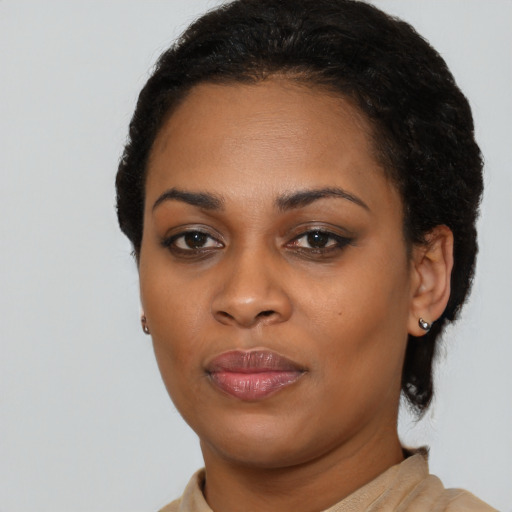 Joyful black young-adult female with short  black hair and brown eyes