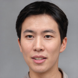 Joyful asian young-adult male with short  brown hair and brown eyes