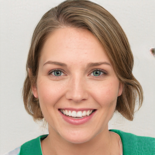 Joyful white young-adult female with medium  brown hair and green eyes