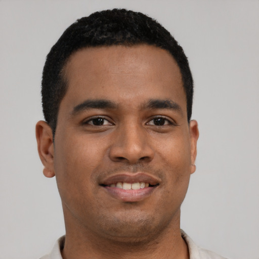 Joyful latino young-adult male with short  black hair and brown eyes