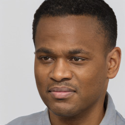 Joyful black young-adult male with short  black hair and brown eyes