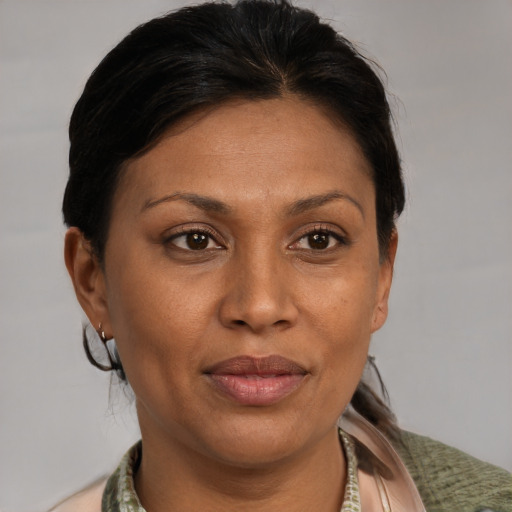 Joyful latino adult female with medium  brown hair and brown eyes
