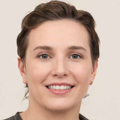 Joyful white young-adult female with short  brown hair and grey eyes