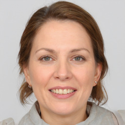 Joyful white adult female with medium  brown hair and grey eyes