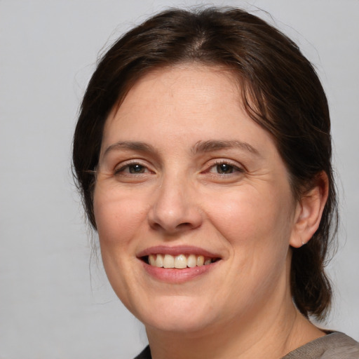 Joyful white adult female with medium  brown hair and brown eyes