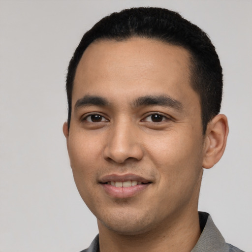 Joyful latino young-adult male with short  black hair and brown eyes