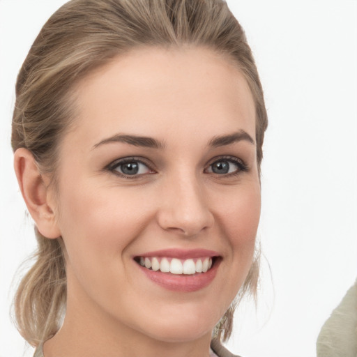 Joyful white young-adult female with medium  brown hair and grey eyes