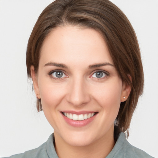 Joyful white young-adult female with medium  brown hair and grey eyes