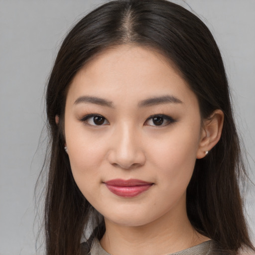 Joyful asian young-adult female with long  brown hair and brown eyes