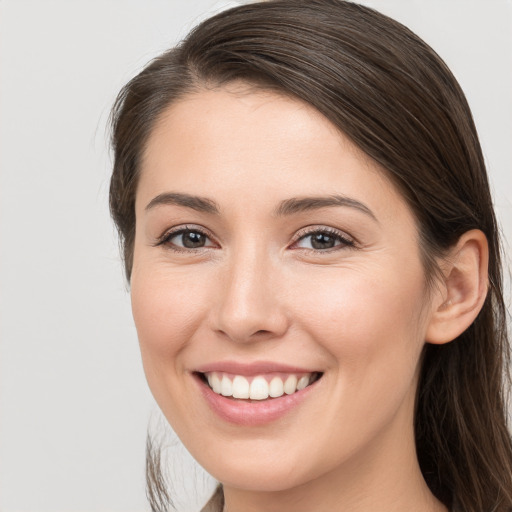 Joyful white young-adult female with long  brown hair and grey eyes