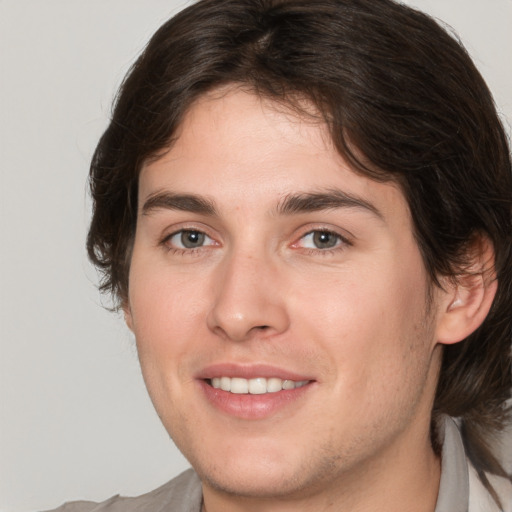 Joyful white young-adult male with medium  brown hair and brown eyes