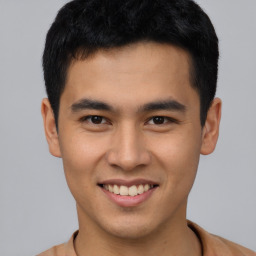 Joyful asian young-adult male with short  brown hair and brown eyes