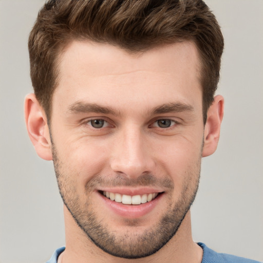 Joyful white young-adult male with short  brown hair and grey eyes