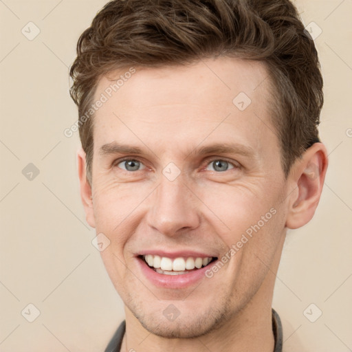 Joyful white adult male with short  brown hair and grey eyes