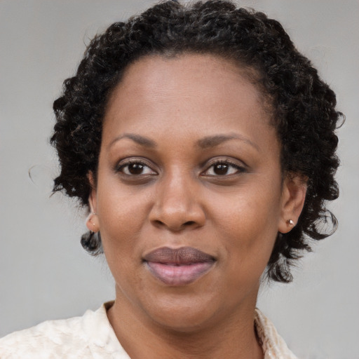 Joyful black adult female with medium  brown hair and brown eyes