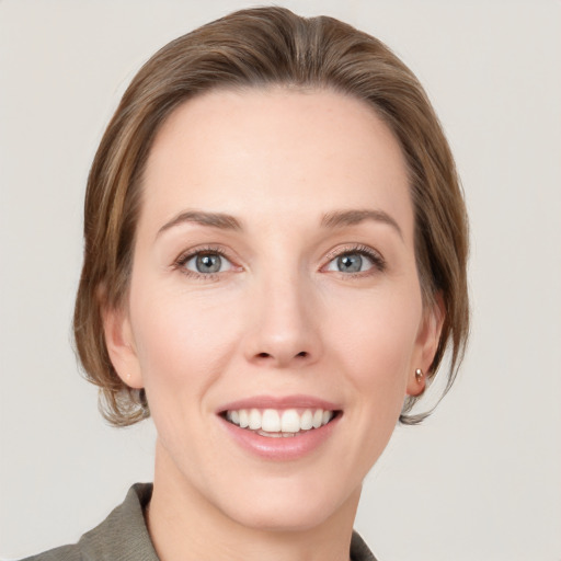 Joyful white young-adult female with medium  brown hair and grey eyes