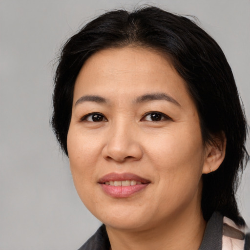 Joyful asian adult female with medium  brown hair and brown eyes