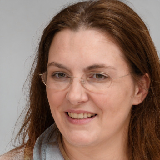 Joyful white adult female with long  brown hair and grey eyes