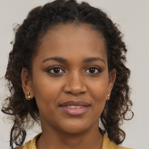 Joyful black young-adult female with long  brown hair and brown eyes