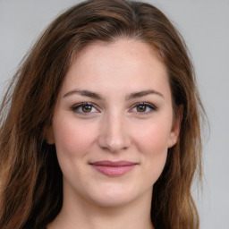 Joyful white young-adult female with long  brown hair and green eyes