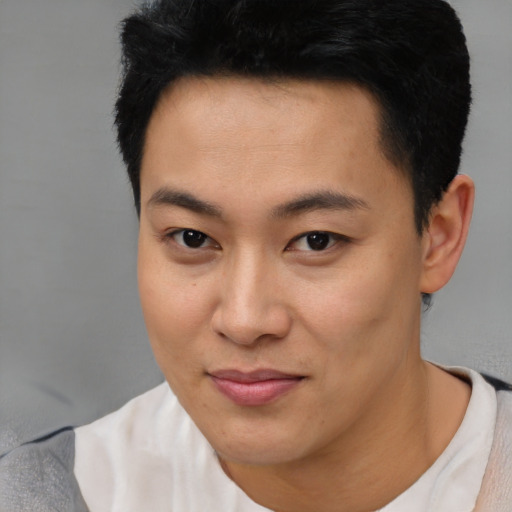 Joyful latino young-adult male with short  black hair and brown eyes