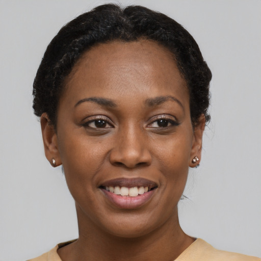Joyful black young-adult female with short  black hair and brown eyes