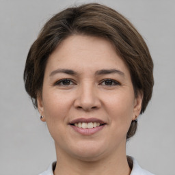 Joyful white young-adult female with medium  brown hair and grey eyes