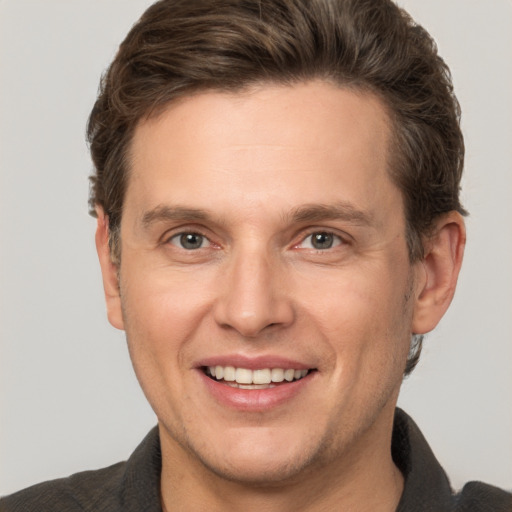 Joyful white adult male with short  brown hair and grey eyes