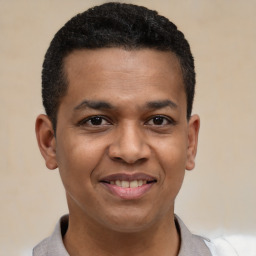 Joyful black young-adult male with short  black hair and brown eyes