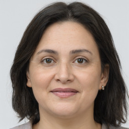 Joyful white adult female with medium  brown hair and brown eyes