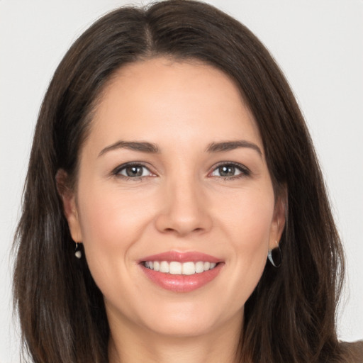 Joyful white young-adult female with long  brown hair and brown eyes