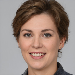 Joyful white young-adult female with medium  brown hair and grey eyes