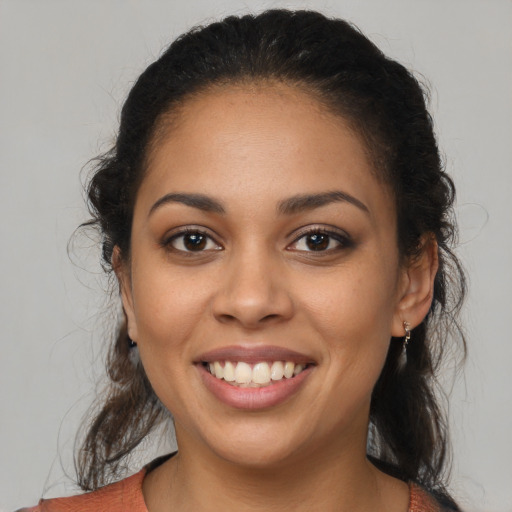 Joyful latino young-adult female with medium  brown hair and brown eyes