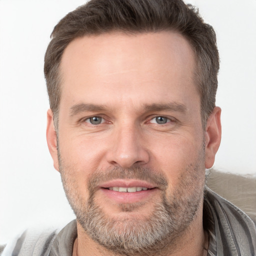 Joyful white adult male with short  brown hair and brown eyes