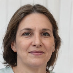 Joyful white adult female with medium  brown hair and brown eyes