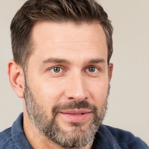 Joyful white adult male with short  brown hair and brown eyes