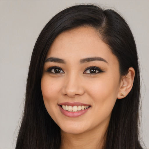 Joyful asian young-adult female with long  brown hair and brown eyes