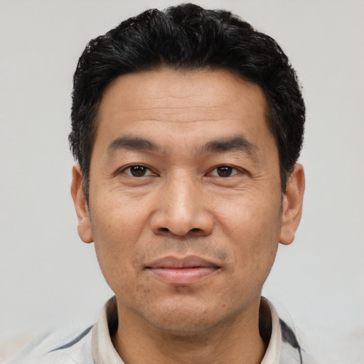 Joyful asian adult male with short  black hair and brown eyes