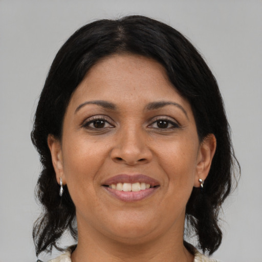 Joyful latino adult female with medium  brown hair and brown eyes